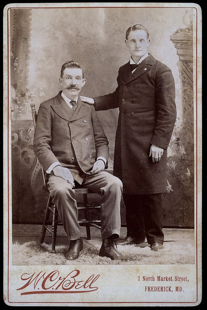Reverend Eavens, a man with a hole in his chest, seated; with Reverend Kipe, standing. Albumen print by W.C. Bell.