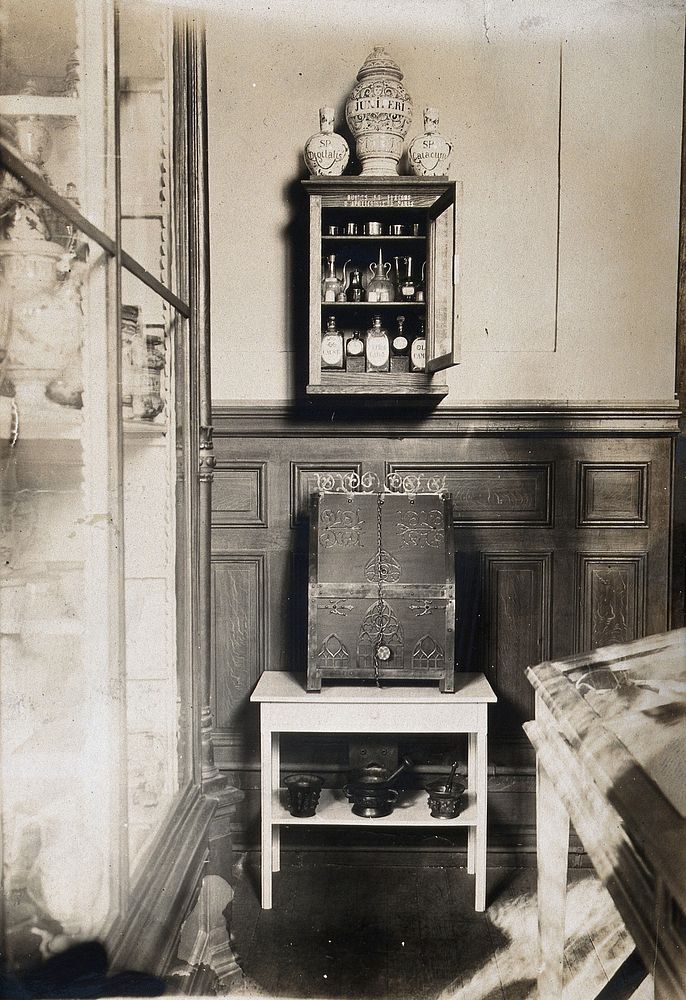 Some objects from the Musée Pharmacie: a small cabinet with pharmacy bottles and jars and a wooden box decorated with metal.…