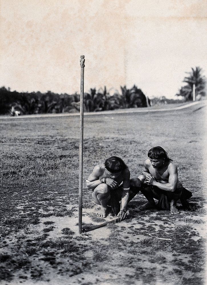 Sarawak: two Kenyah people consulting a sundial. Photograph.
