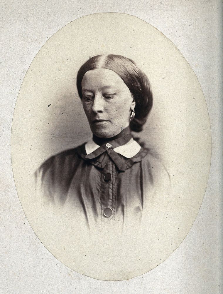 A woman's head and shoulders, her face is tilted to the right and her eyes are looking down. Photograph by L. Haase after…