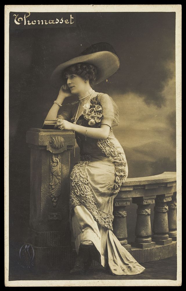 Thomasset, an actor in drag, poses wearing a large hat. Photographic postcard, 190-.