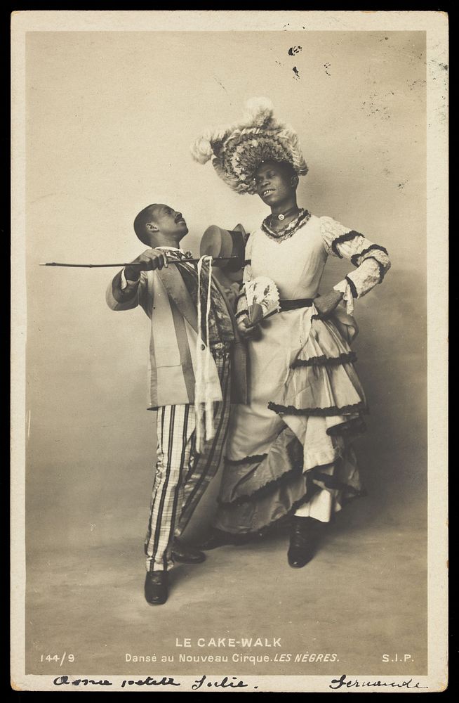 Two black actors, Gregory and Brown, one in drag, dancing the Cake-Walk in Paris. Photographic postcard, 1903.