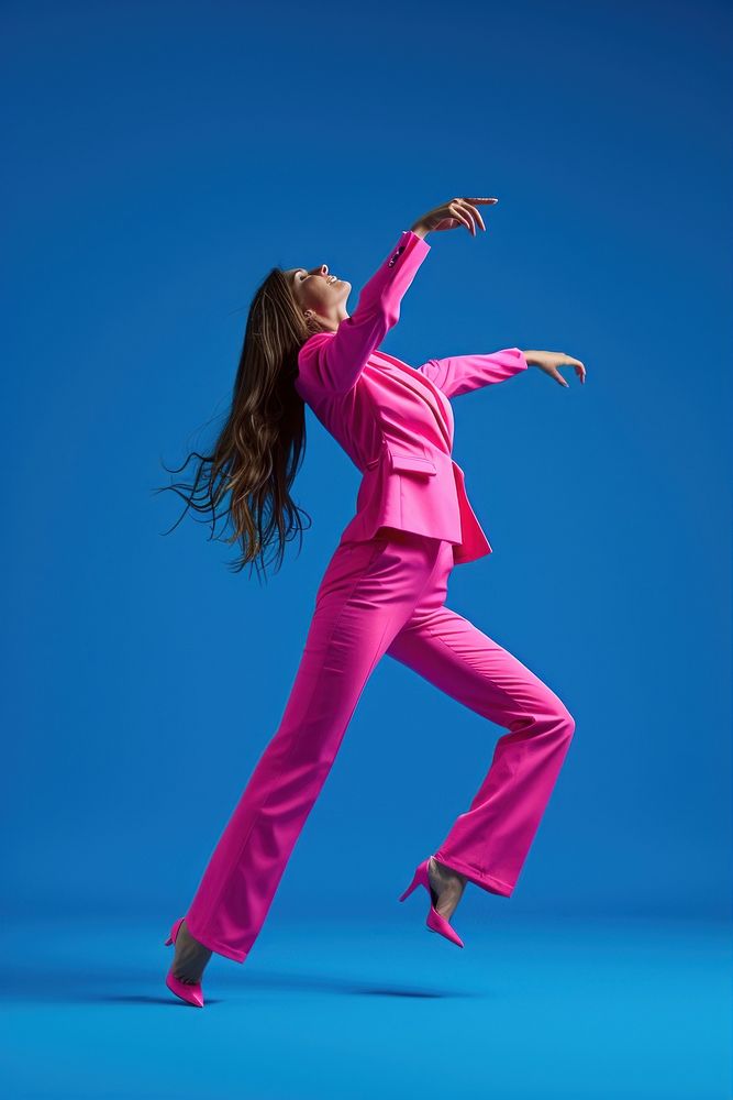 Woman in pink suit in front of blue dancing adult entertainment performance.