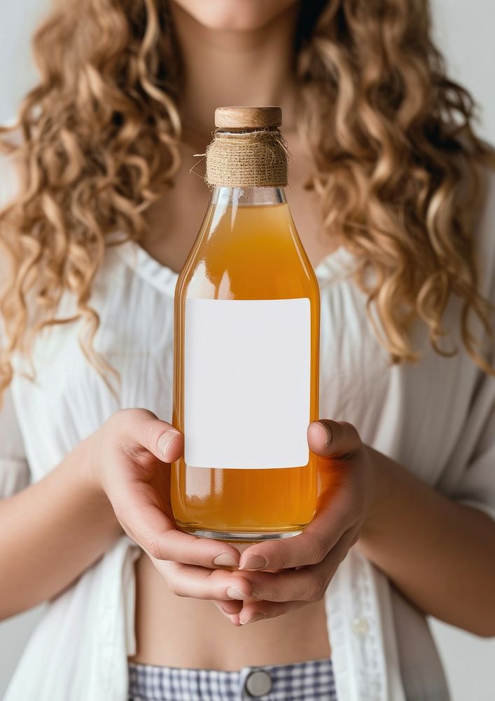 Woman holding a bottle of apple juice label drink food.