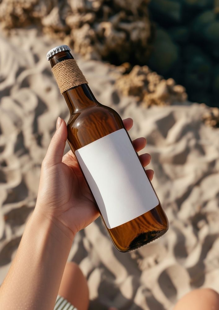 Woman holding a bottle of beer outdoors summer drink.