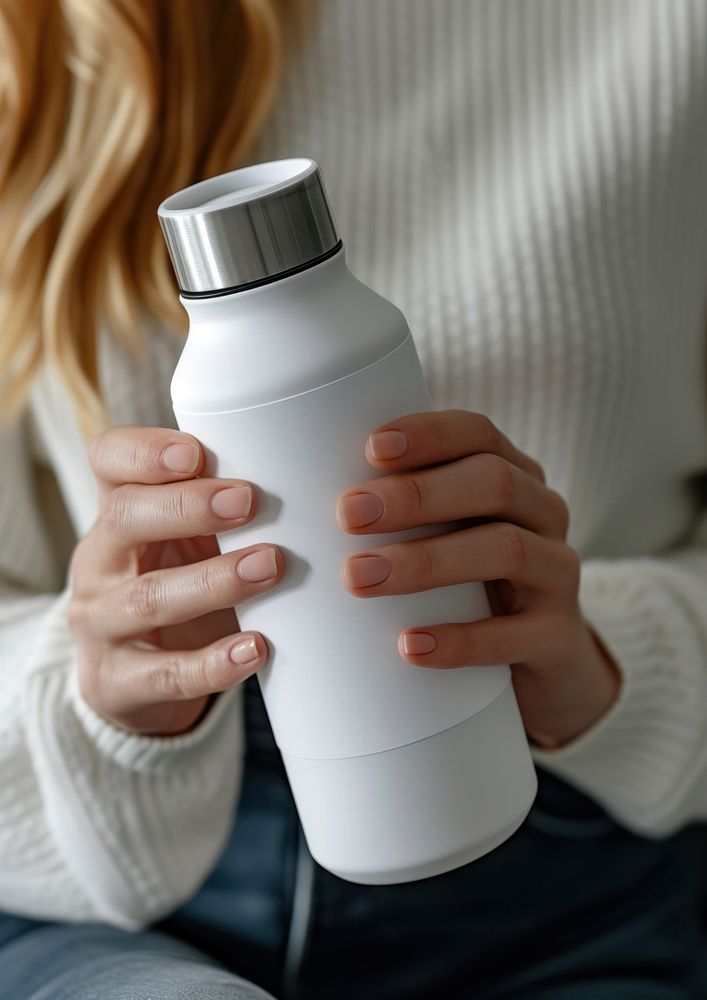 Woman holding a bottle of thermos refreshment drinkware container.