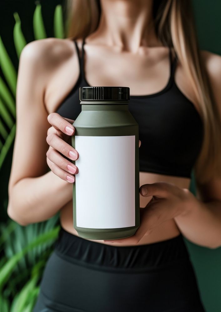 Woman holding a bottle of protein shaker jar refreshment exercising.