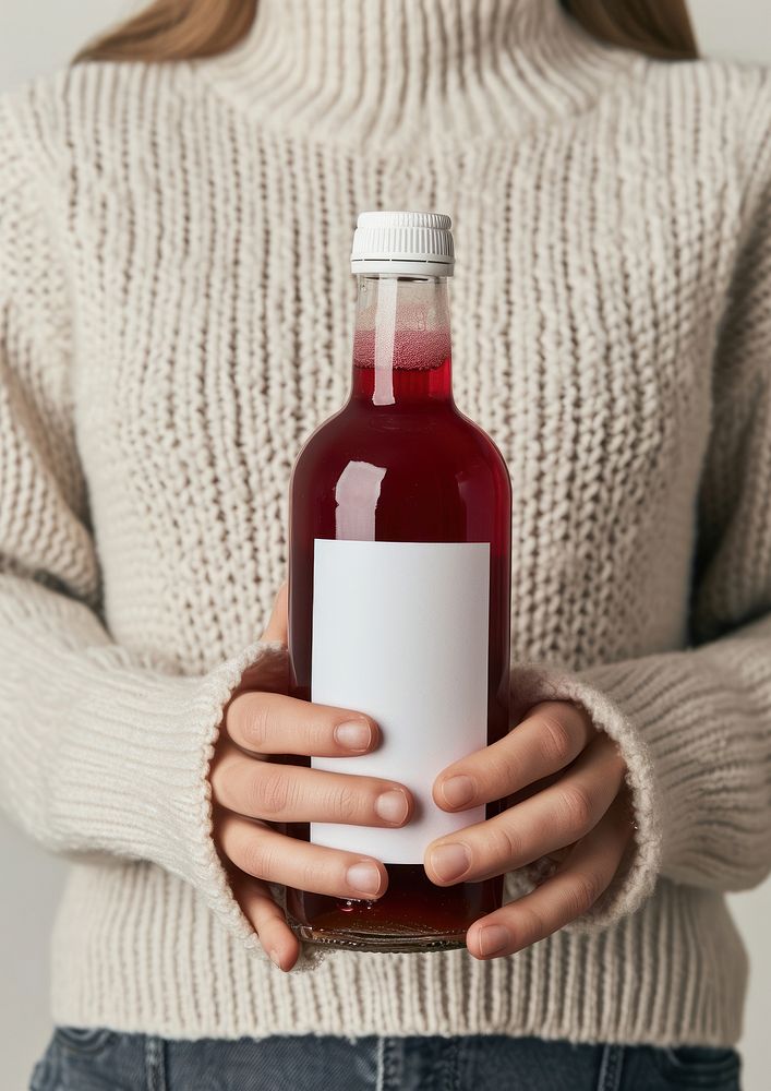 Woman holding a bottle of grape juice sweater drink wine.