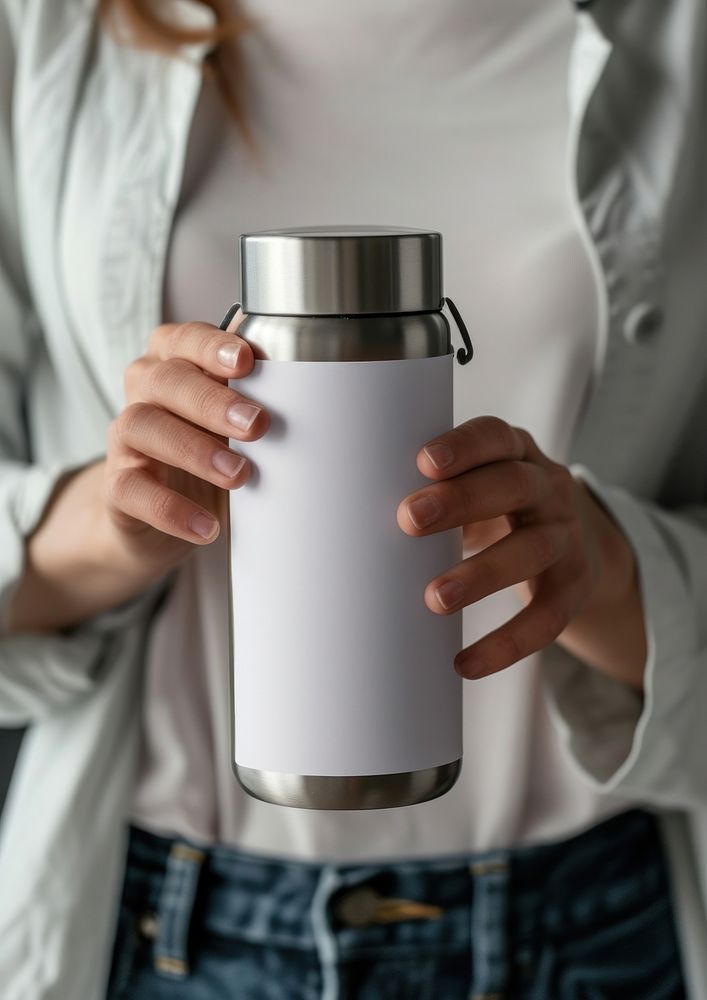 Woman holding a bottle of thermos refreshment midsection container.