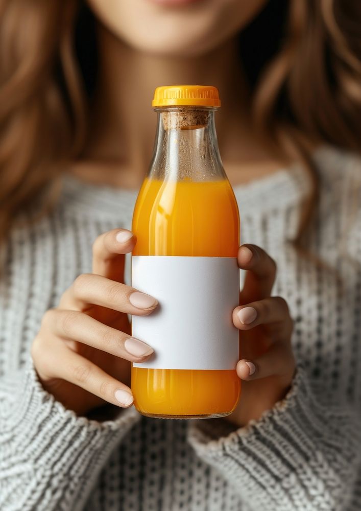 Woman holding a bottle of orange juice drink refreshment midsection.
