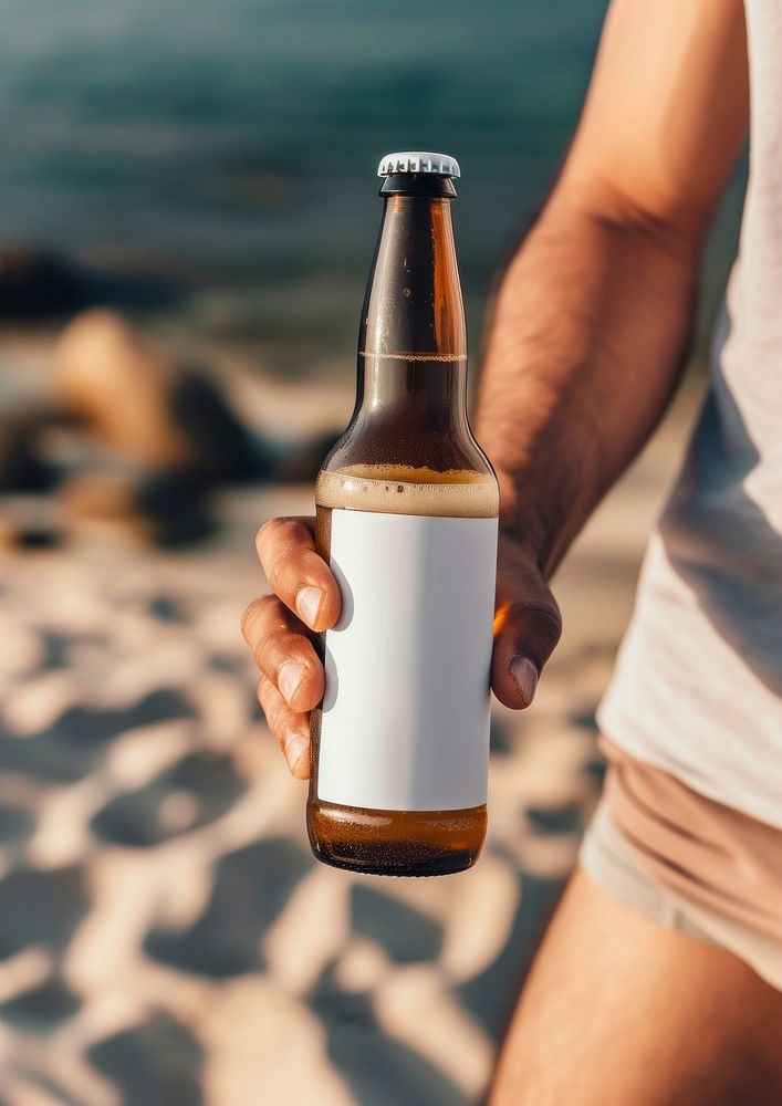 Man holding a bottle of beer summer beach drink.