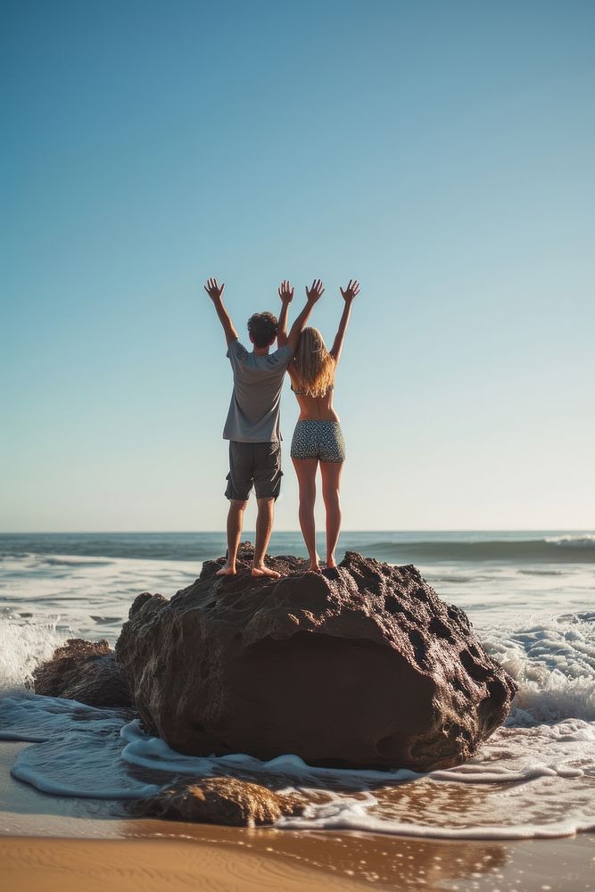 Couple standing on a rock at the beach outdoors vacation nature.
