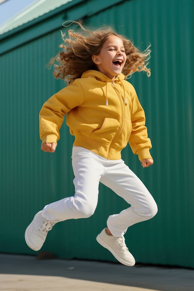 Happy girl kid is jumping yellow child pants.