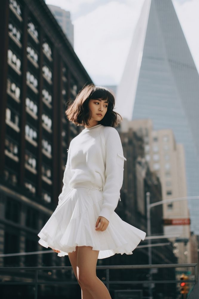 Woman wearing white asymmetric skort architecture dress skirt.