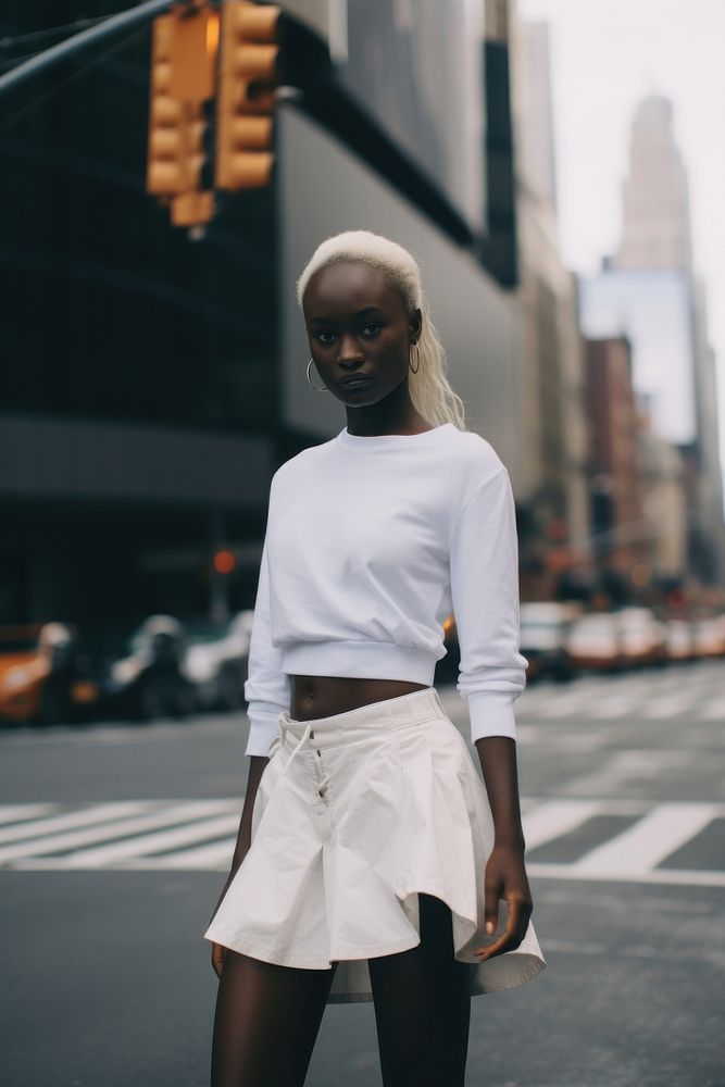 Woman wearing white asymmetric skort miniskirt street architecture.