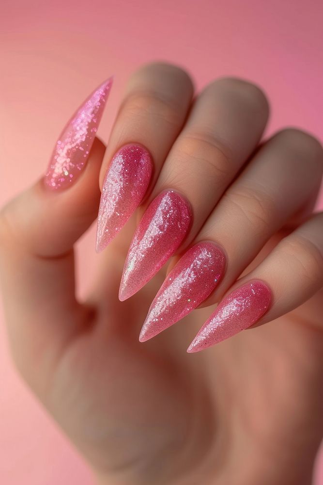 Show hand giltter pink manicure made of shell nail polish cosmetics fingernail jewelry.