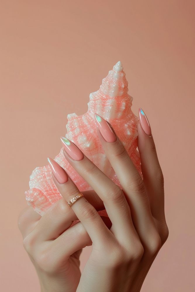 Show hand giltter pink manicure made of shell nail polish jewelry finger skin.