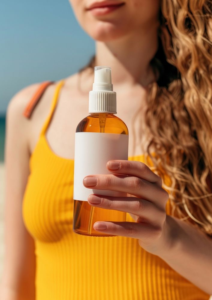 Woman holding a bottle of sunscreen spray refreshment container hairstyle.