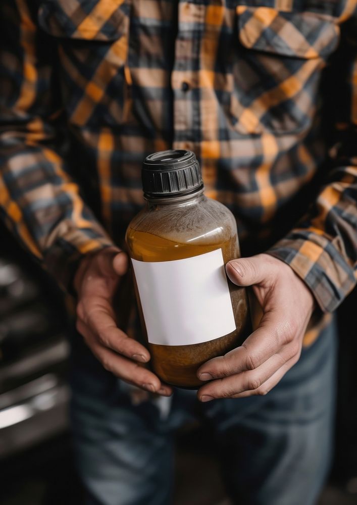 Man holding a canister with machine oil for car bottle refreshment midsection.