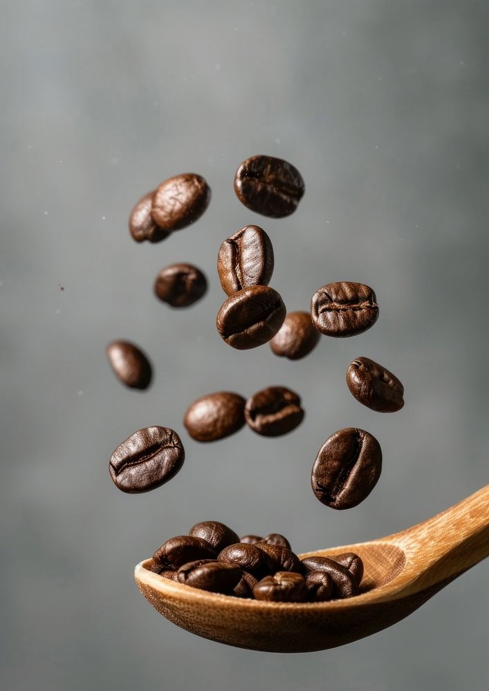 A coffee beans falling on the wood spoon refreshment freshness beverage.