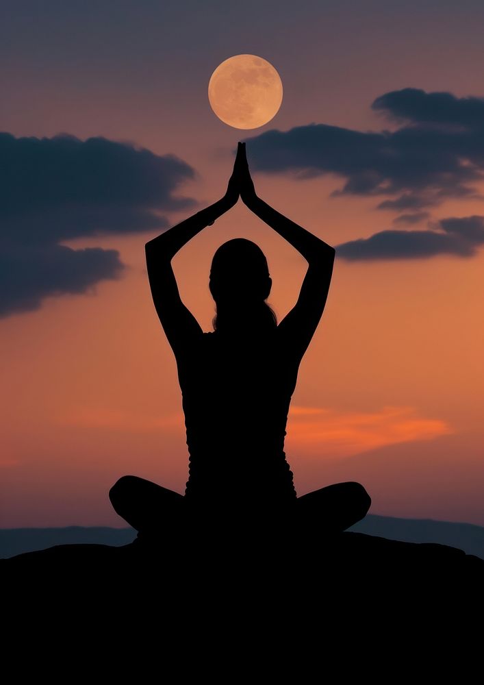 A woman silhouette sitting put the hand together above the head or doing yoga on the mountain in front of the moon…