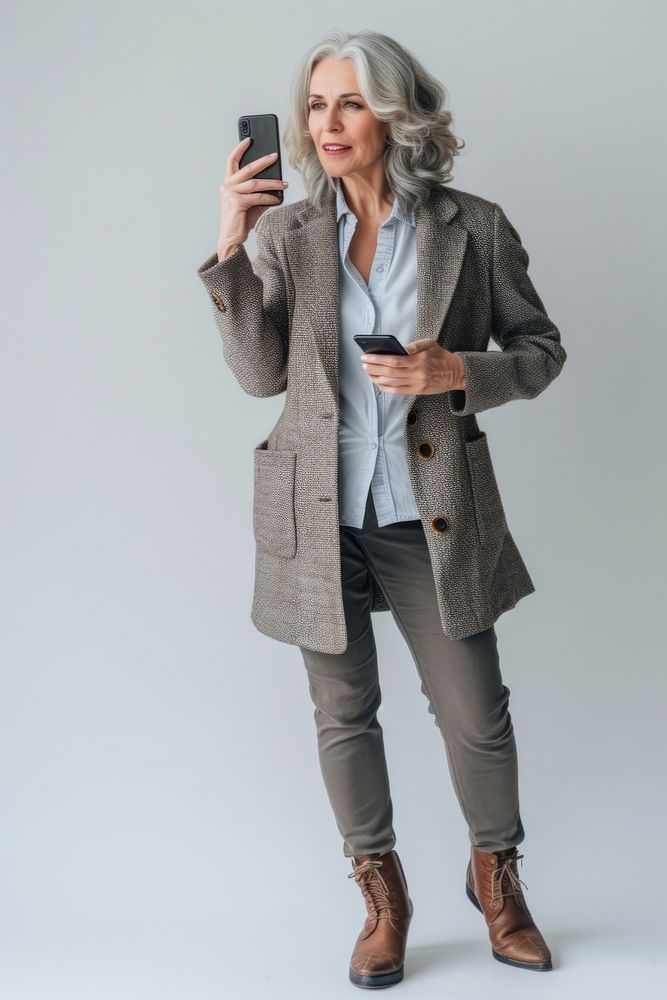 Mature businesswoman using mobile phone overcoat jacket adult.