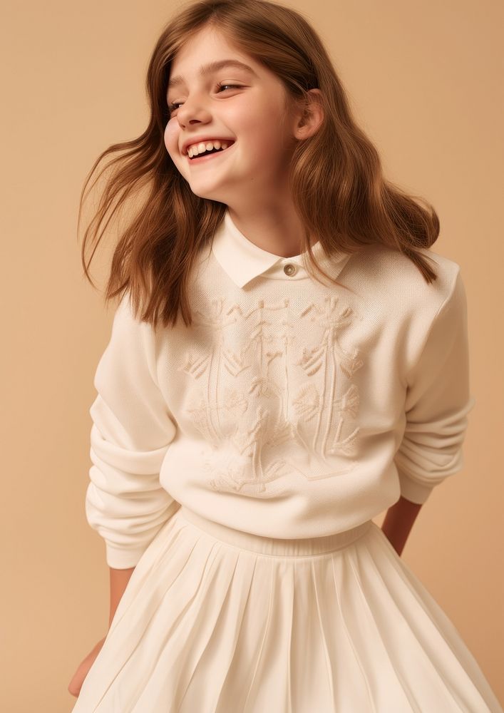 Cheerful kid wearing white embroidered polo sweatshirt and white contrast pleated skirt portrait blouse photo.