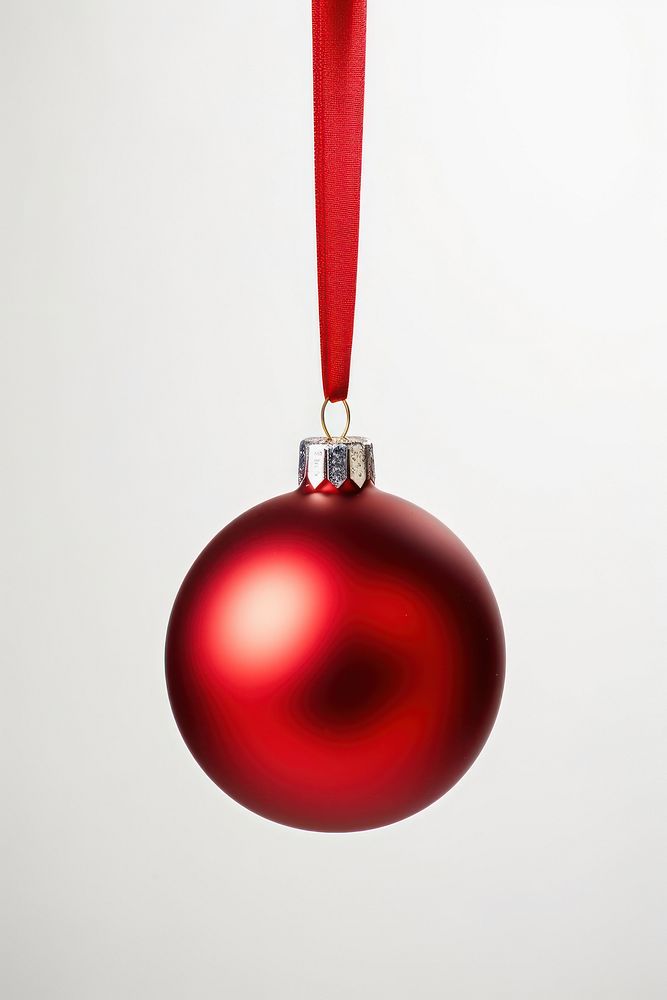 Red Christmas bauble hanging from red ribbon christmas white background celebration.