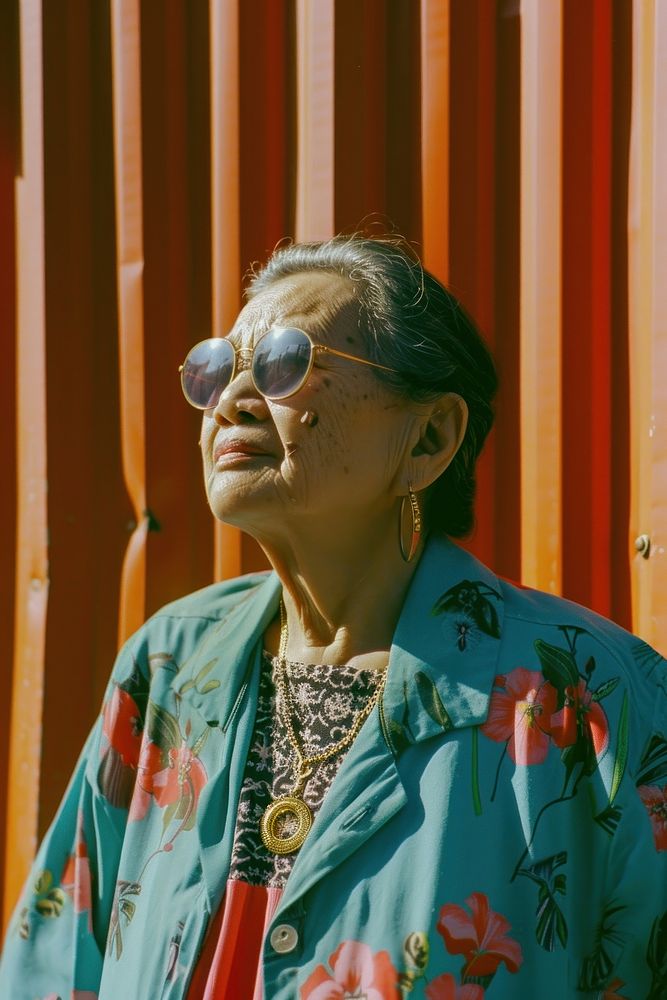 Old woman wearing blue streetwear clothes portrait necklace glasses.