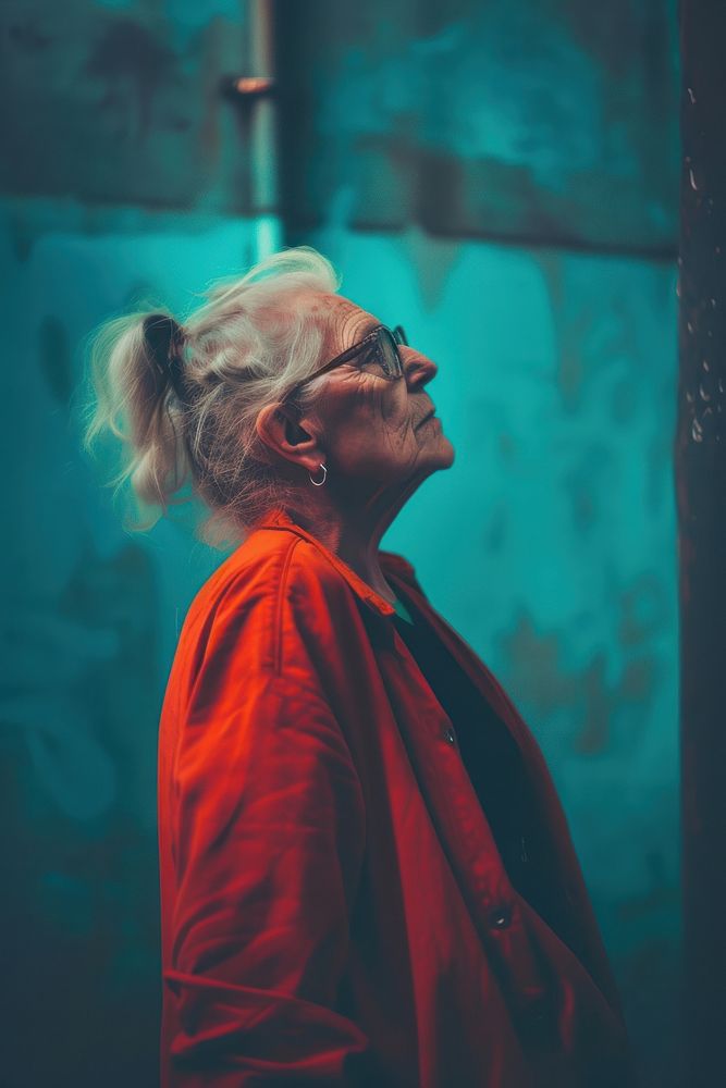 Old woman wearing red streetwear clothes portrait photo contemplation.
