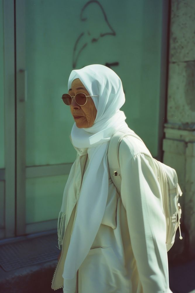 A old woman wearing white hijab and white streetwear clothes glasses adult architecture.