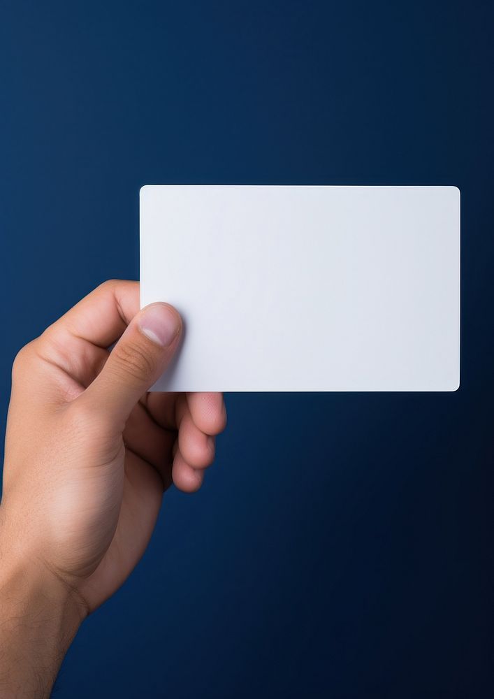Hand holding a white business card blue electronics showing.
