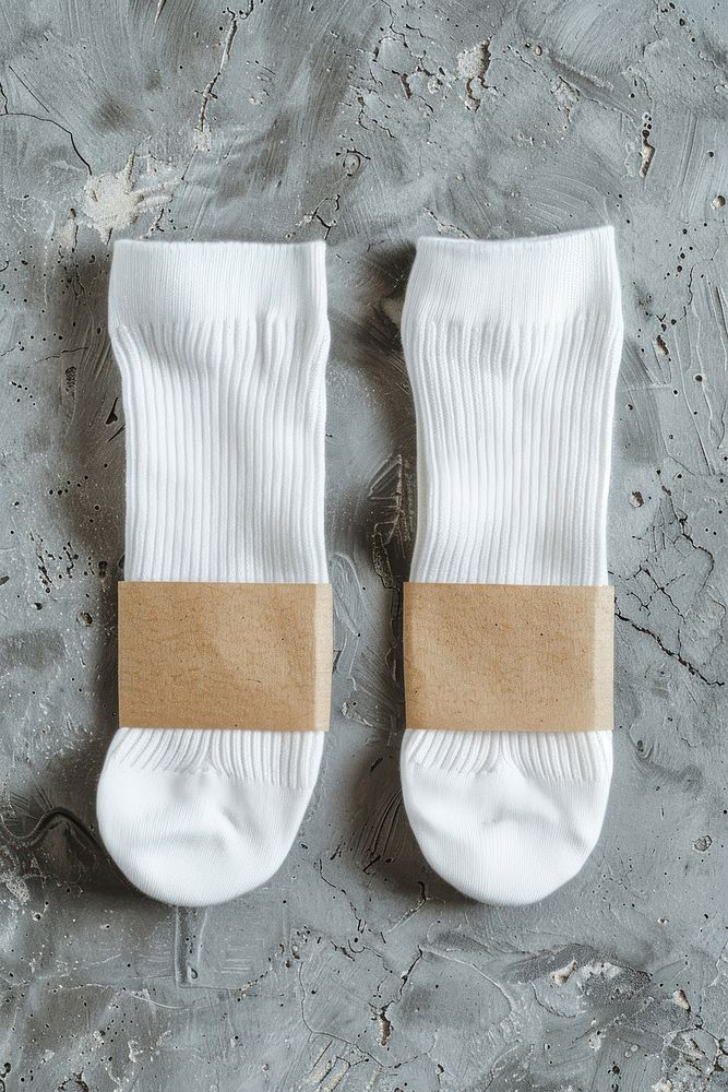 Two white socks are folding with empty wrap label clothing bandage textile.