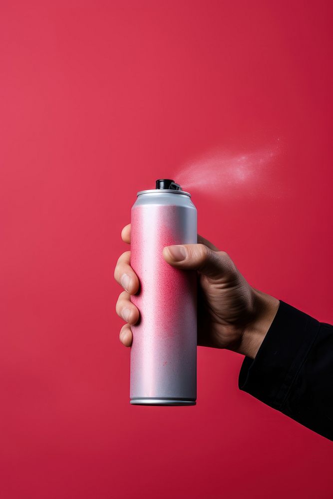Hand holding spray can bottle refreshment cylinder.