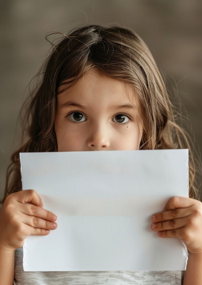 A little girl cute smile with a white sheet of blank white paper portrait child photo.