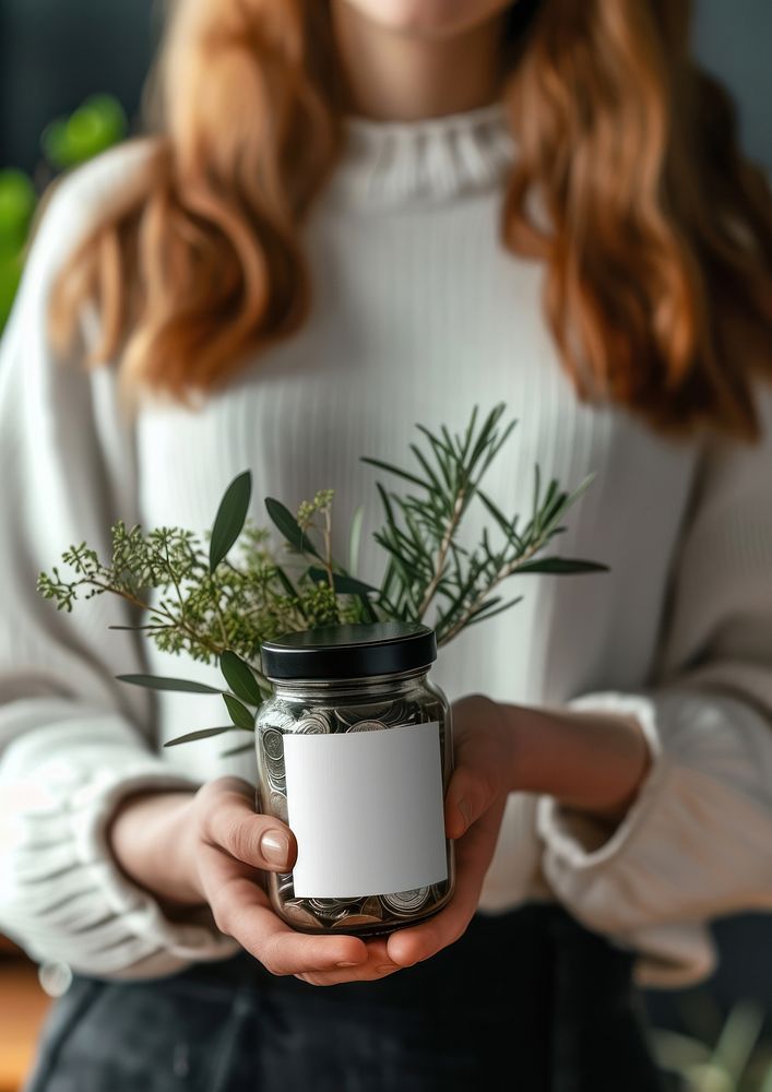 Woman holding a jar of coins houseplant flowerpot container.