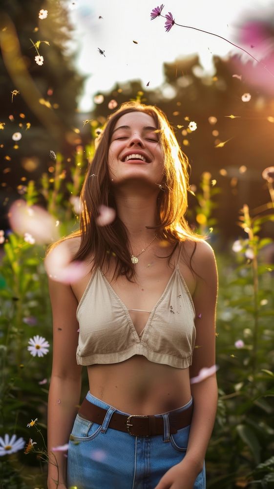 Woman in garden with flying flowers laughing portrait smile.