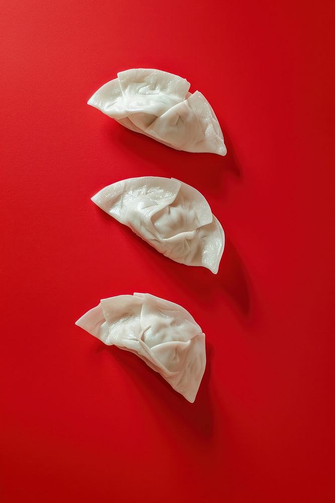 Photo of 3 dumpling food red red background.