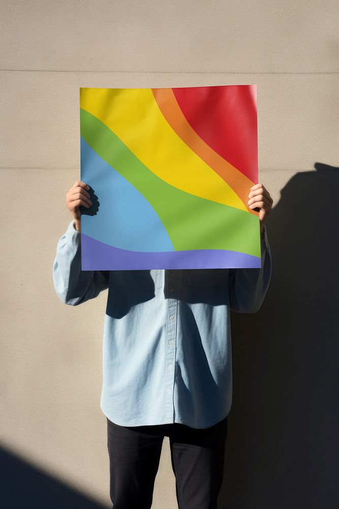 Man holding LGBTQ+ poster