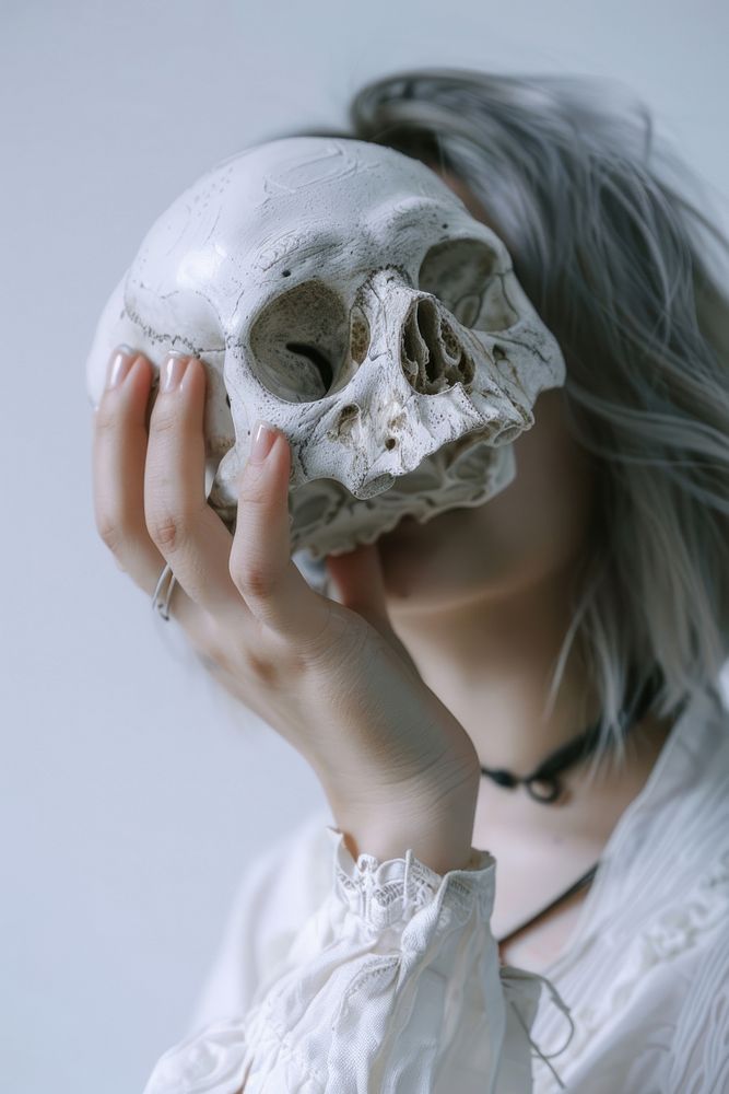 Hand holding a human skull portrait adult white.