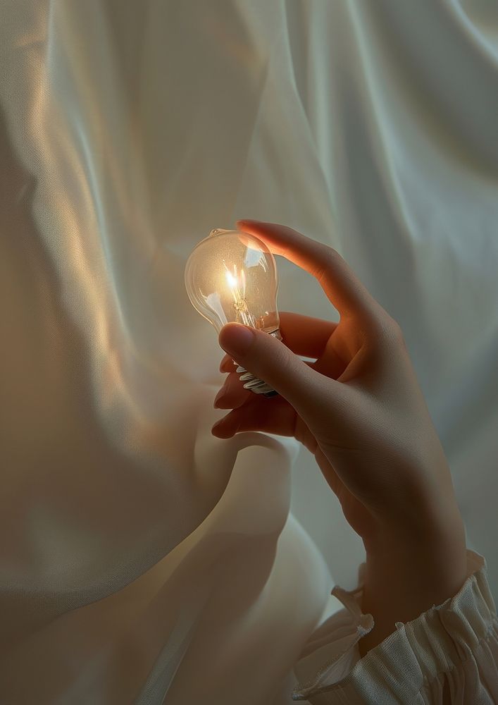 Woman holding light bulb lightbulb hand illuminated.