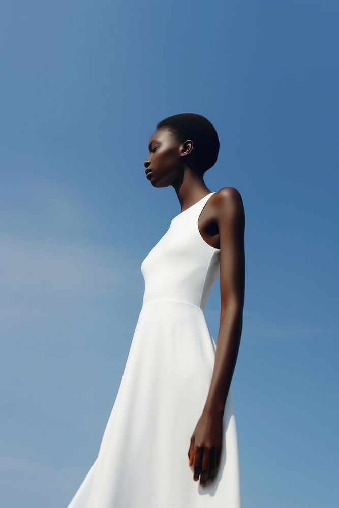 A black teenage woman wearing minimal white dress fashion gown sky.