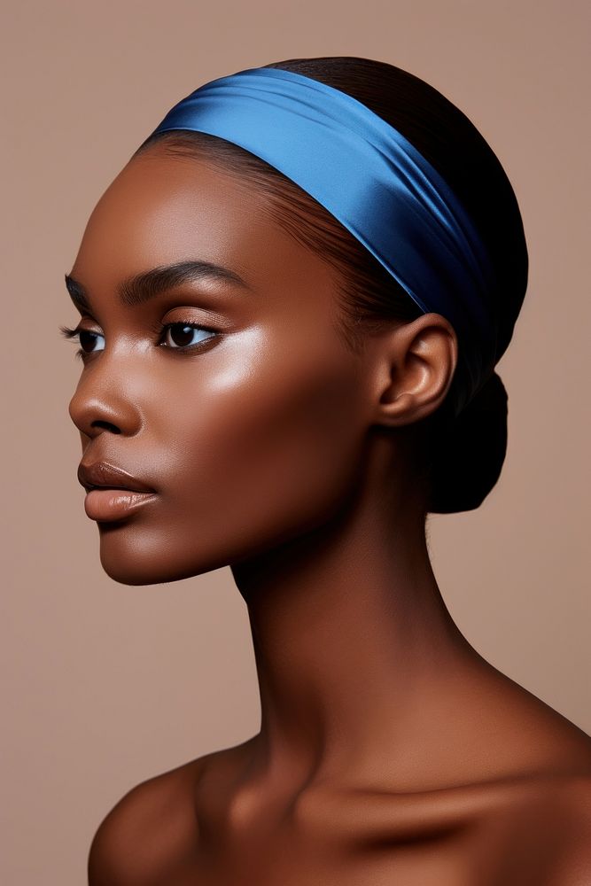 A black woman wearing blue eyeliner with modern brown 2023 headband fashion adult accessories.