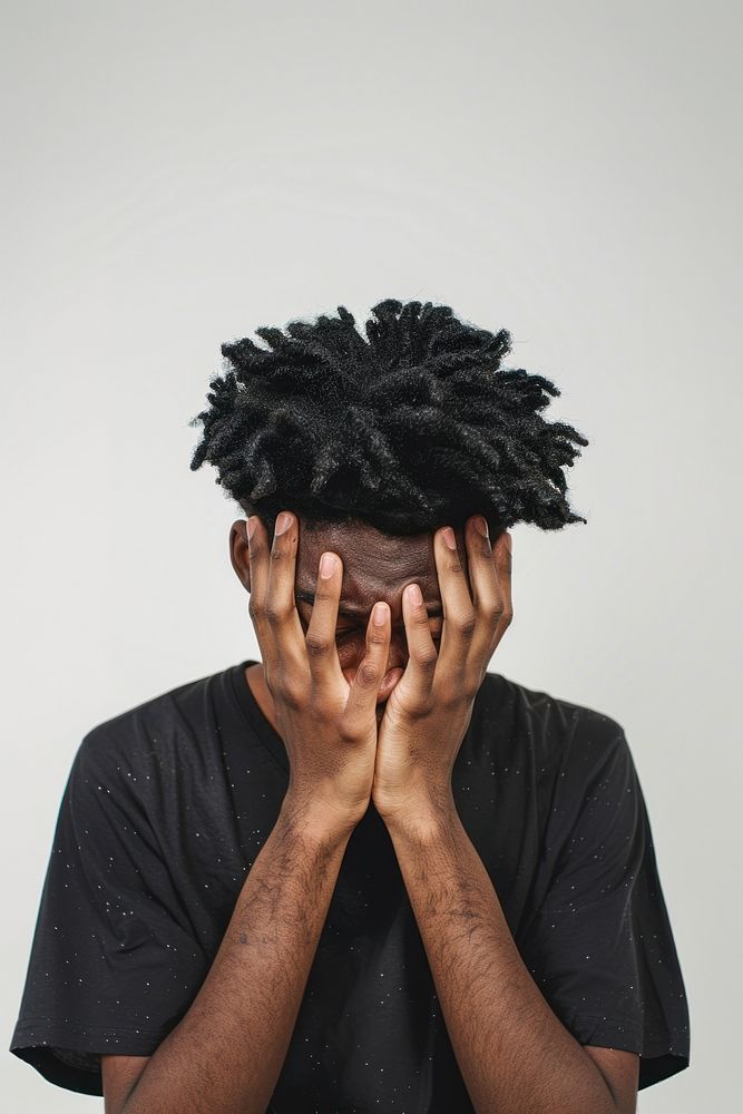 Depressed young black man hiding head in hands portrait adult photo.