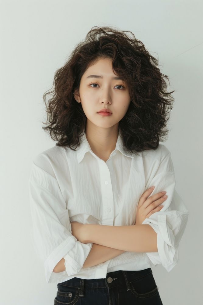 Radiant young korean woman with stunning curls who feels confident portrait blouse white.