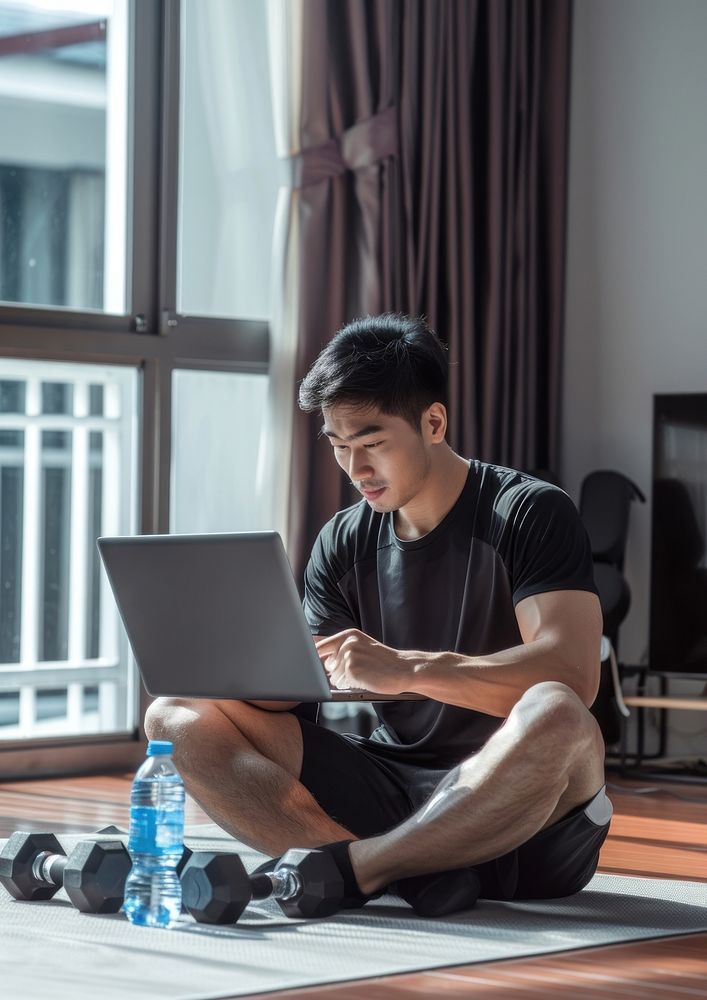 Thai sporty man sitting laptop electronics.