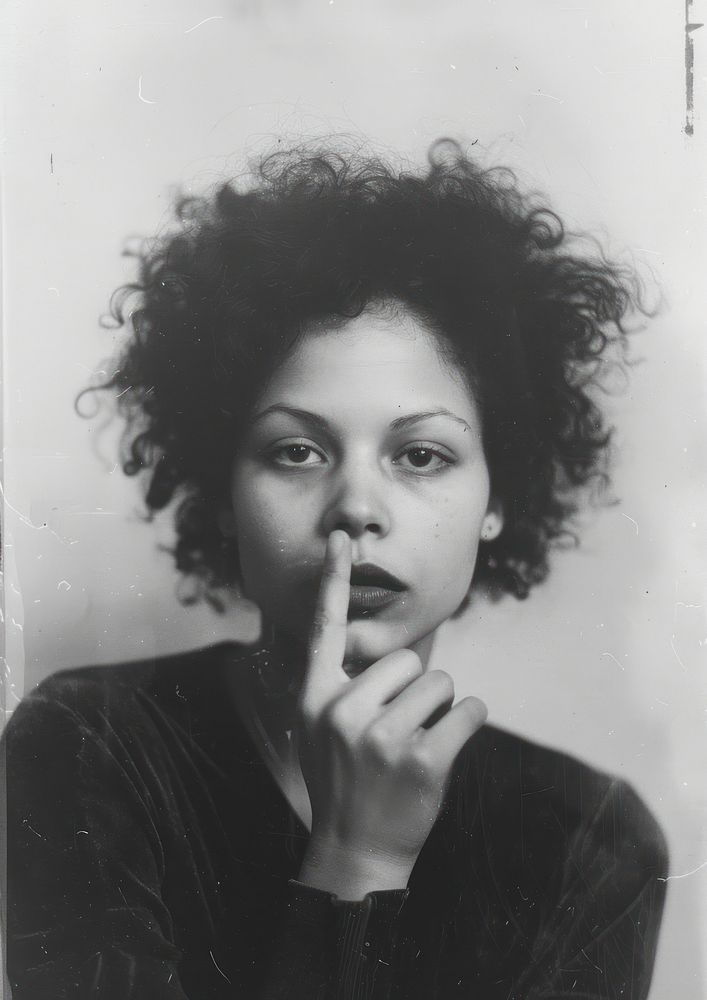 A woman put her finger in front of her mouth as a symbol of silence photography portrait person.