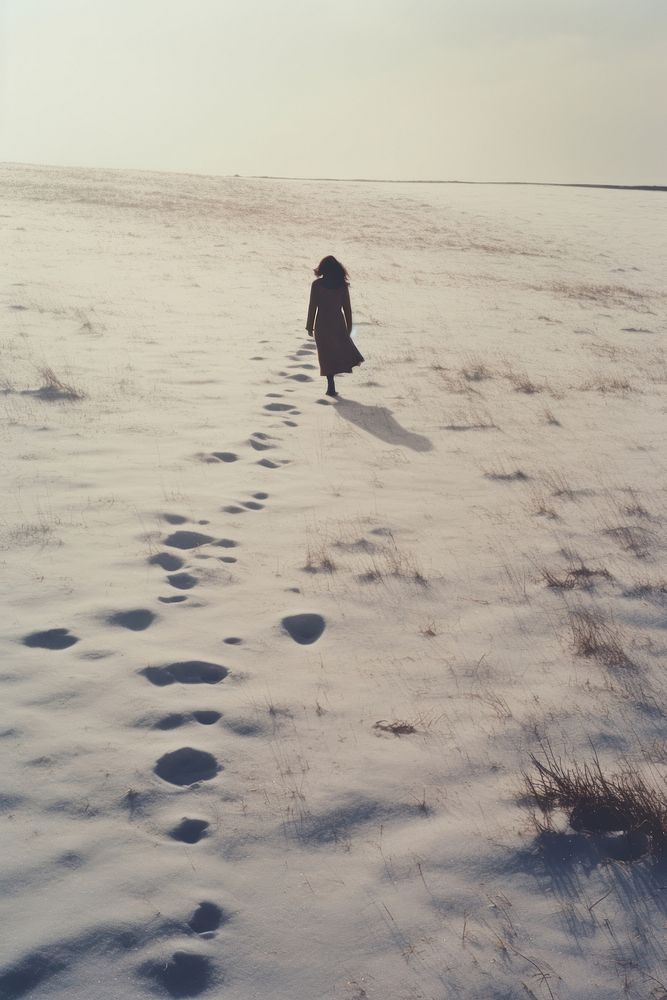 Woman walking in snow landscape footprint outdoors.