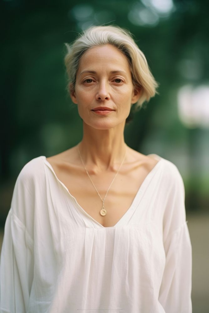 A mature woman wear white accessories accessory necklace.