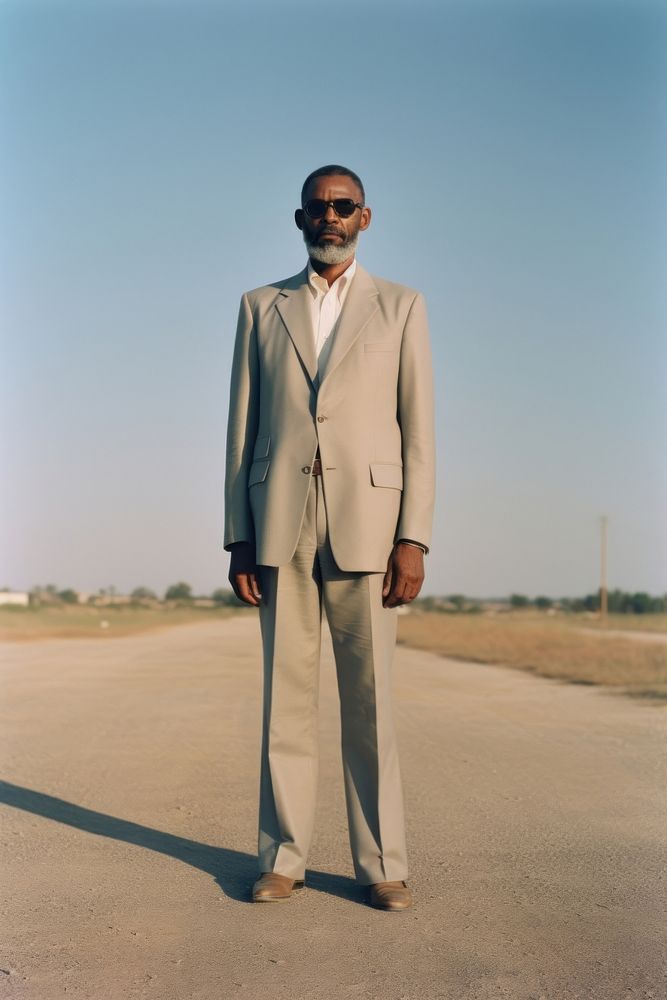 Full body portrait a mature affrican man suit clothing standing.
